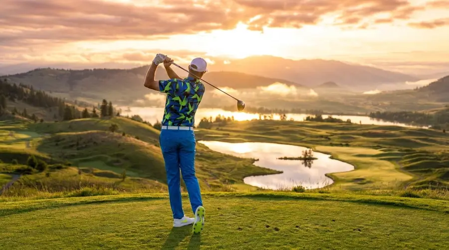Sean teeing off at sunset over an Okanagan golf course